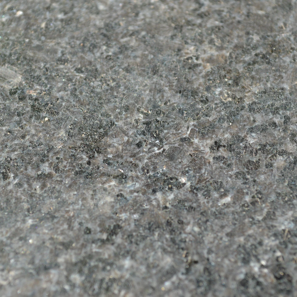 Fotografía de piedra natural de grano oscuro y gris, comercializada como granito negro.